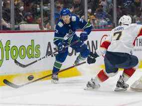 L'attaquant des Canucks de Vancouver Alex Chiasson passe la rondelle autour du défenseur des Panthers de la Floride Radko Gudas en première période au Rogers Arena.  Les Canucks ont perdu 2-1 en fusillade.