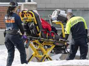 Les ambulanciers transportent un patient à l'urgence alors que les hospitalisations continuent d'augmenter en raison de la pandémie de COVID-19 le mercredi 5 janvier 2022 à Montréal.