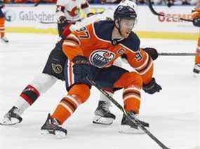 L'attaquant des Oilers d'Edmonton Connor McDavid transporte la rondelle autour de l'attaquant des Sénateurs d'Ottawa Brady Tkachuk lors de la première période à Rogers Place.