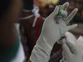 Un agent de santé se prépare à administrer le vaccin Covishield contre le COVID-19 dans les locaux d'un temple à Hyderabad, en Inde, le mercredi 12 janvier 2022.