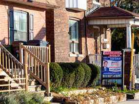 Un panneau à vendre est affiché à l'extérieur d'une maison à Toronto.