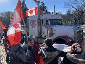 Les gens se rassemblent pour soutenir les camionneurs opposés aux mandats de vaccination au Palais législatif de la Saskatchewan à Regina, le samedi.  29 janvier 2022.