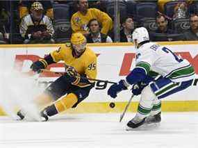 Le centre des Nashville Predators Matt Duchene (95 ans) poursuit la rondelle alors qu'il est défendu par le défenseur des Canucks de Vancouver Oliver Ekman-Larsson (23 ans) lors de la deuxième période d'un match de hockey de la LNH le mardi 1er février 2022 à Nashville, Tennessee.