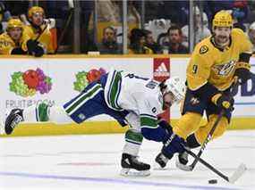 L'ailier droit des Canucks de Vancouver Conor Garland (8) atteint la rondelle devant l'ailier gauche des Predators de Nashville Filip Forsberg (9) lors de la première période d'un match de hockey de la LNH le mardi 1er février 2022 à Nashville, Tennessee.