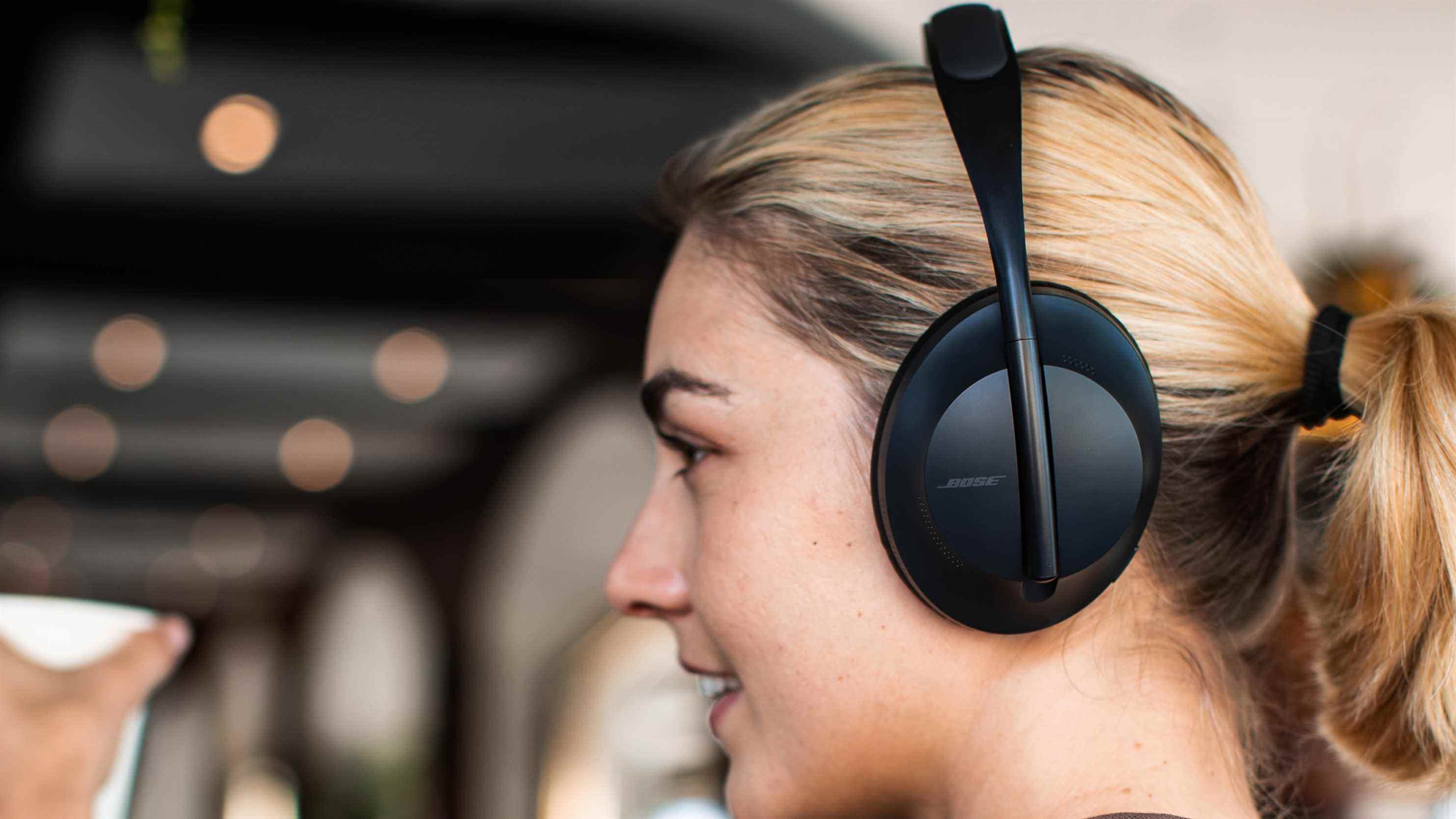 Une femme portant le casque bose Noise Cancelling Headphones 700 en noir