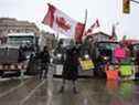 Un partisan de la manifestation Freedom Convoy agite un drapeau canadien devant la colline du Parlement, au centre-ville d'Ottawa, le 8 février 2022. Photo de Jean Levac/Postmedia