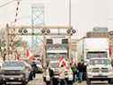 Les partisans du convoi de camionneurs contre le mandat du vaccin COVID-19 bloquent la circulation dans les voies en direction du Canada du poste frontalier du pont Ambassador, à Windsor, en Ontario, mardi.  Environ 323 millions de dollars de marchandises traversent la frontière Windsor-Detroit chaque jour au pont Ambassador, ce qui en fait le passage frontalier international le plus achalandé en Amérique du Nord.