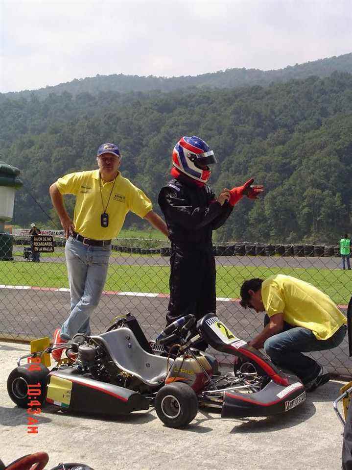 un pilote casqué enfile ses gants de course avant de prendre place sur un kart de Formule A