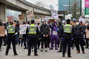 Des contre-manifestants bloquent un convoi alors que les camionneurs et les partisans continuent de protester contre les mandats de vaccination, à Vancouver ce week-end.