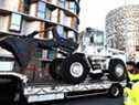 Des policiers se tiennent à côté d'un camion transportant un bulldozer à la porte d'Orléans, dans le sud de Paris, le 11 février 2022, alors que des convois de manifestants, inspirés par des camionneurs canadiens, devraient arriver dans la capitale française.
