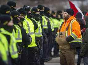 Les manifestants crient après la police alors qu'ils tentent de dégager le blocus anti-mandat du pont Ambassador sur Huron Church Road, le samedi 12 février 2022.