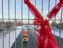 Un camion passe sous un pont piétonnier sur la route depuis le poste frontalier du pont Ambassador à Windsor, en Ontario, lundi.  Le point de passage terrestre le plus fréquenté du Canada avec les États-Unis est à nouveau ouvert après avoir été bloqué pendant près d'une semaine par des manifestations.  Les chefs de file de l'économie et de l'industrie évaluent les dégâts.