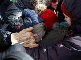 Des enfants dans la file de manifestants et de partisans séparant le site d'occupation du Freedom Convoy et l'avancée de la police sont bousculés, à Ottawa, le 18 février 2022.