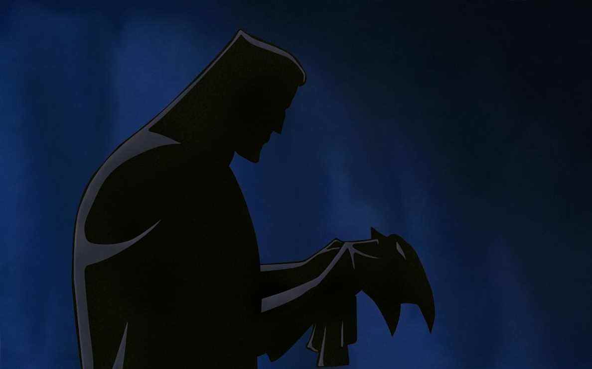 un homme regarde un masque dans batman : masque du fantasme