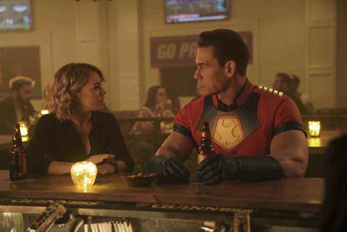 Jennifer Holland et John Cena sont assis dans un bar dans une scène de Peacemaker.