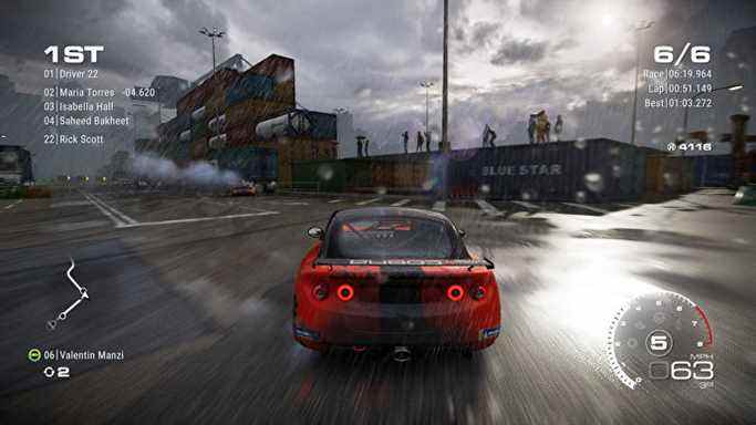 Une voiture rouge roule dans les rues glissantes de la ville dans Grid Legends