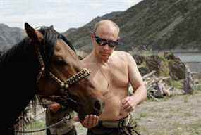 Une photo d'archive prise le 3 août 2009 montre le président russe Vladimir Poutine nourrissant un cheval pendant ses vacances à l'extérieur de la ville de Kyzyl, dans le sud de la Sibérie.