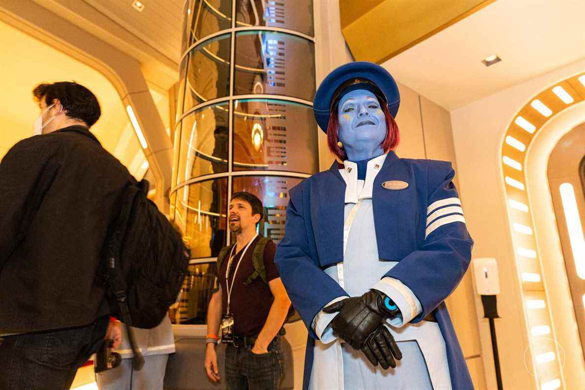 Le capitaine du navire, vêtu de bleu.  Ses cheveux sont rouge foncé.