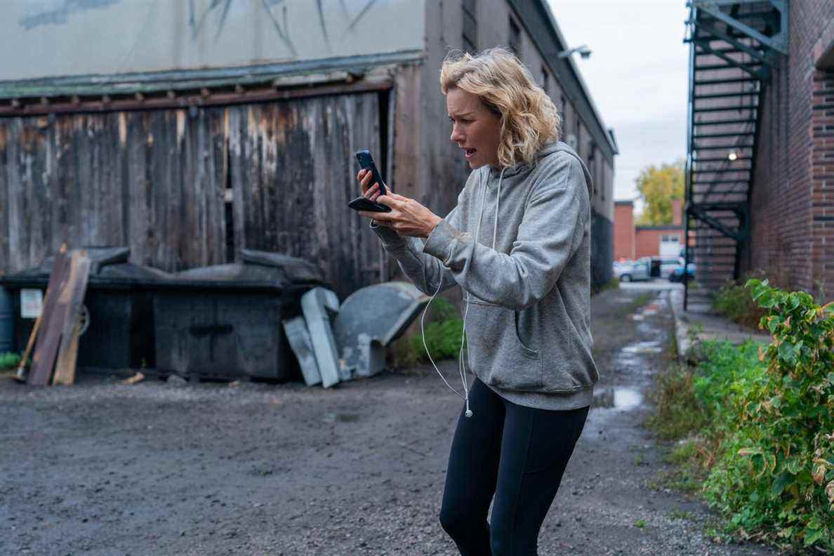 Naomi Watts crie anxieusement sur son téléphone dans une ruelle