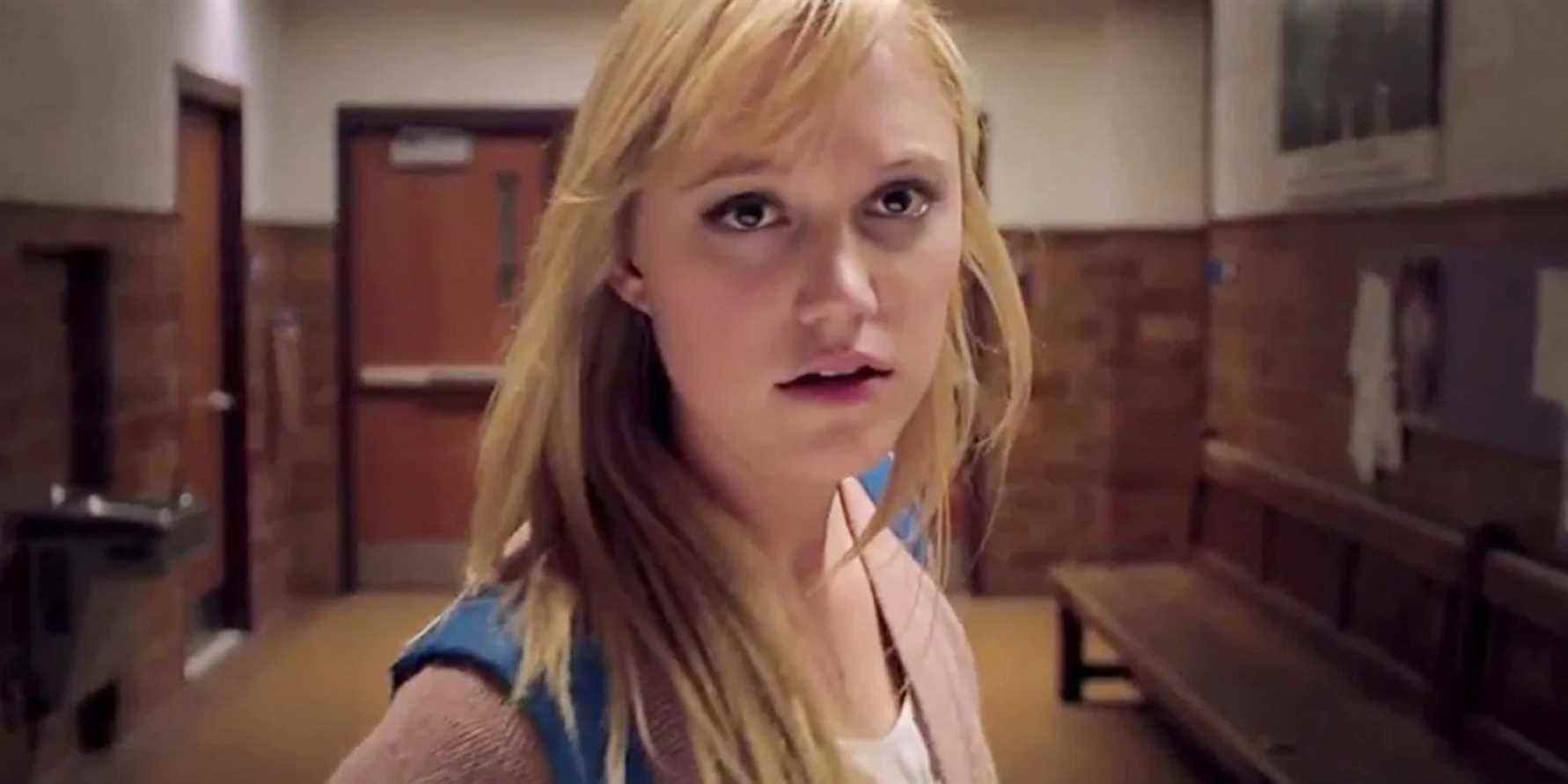 Jay (Maika Monroe) debout dans le couloir de son lycée dans It Follows