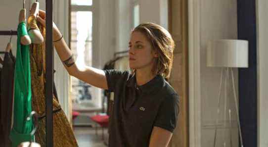 Kristen Stewart as Maureen holding up clothes in Personal Shopper