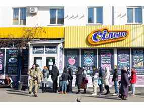 Des gens font la queue devant l'épicerie du quartier de Solomianska le 26 février 2022 à Kiev.