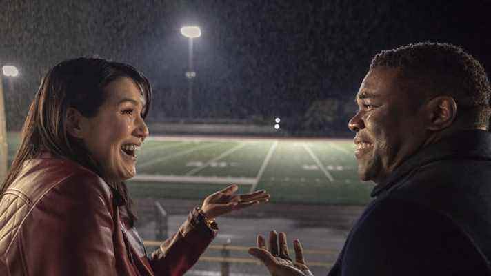 Zoe (Zoe Chao) et Aniq (Sam Richardson) rient ensemble sur les gradins dans The Afterparty sur Apple TV+.