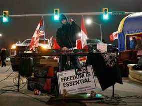 Un DJ joue alors que les manifestants et les partisans assistent à un blocus au pied du pont Ambassador, bloquant le flux de trafic commercial sur le pont vers le Canada depuis Detroit jeudi à Windsor.  Alors qu'un convoi de camionneurs et de partisans continue d'occuper le centre-ville d'Ottawa, des blocus et des convois ont surgi dans tout le pays pour soutenir la protestation contre le mandat de vaccination du Canada contre la COVID-19 pour les camionneurs transfrontaliers.