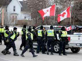 La police encercle une camionnette alors qu'elle élimine les manifestants contre les mandats de vaccination contre la COVID-19 qui ont bloqué l'entrée du pont Ambassador à Windsor, en Ontario, le 13 février 2022.