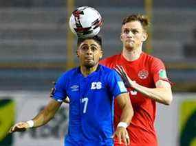 Le milieu de terrain d'El Salvador Jairo Henriquez (L) et le défenseur canadien Scott Kennedy regardent le ballon lors du match de football de qualification de la Concacaf pour la Coupe du Monde de la FIFA entre El Salvador et le Canada au stade Cuscatlan de San Salvador le 2 février 2022.