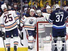 L'ailier droit des Oilers d'Edmonton Kailer Yamamoto (56 ans) célèbre son deuxième but en période contre le gardien des Jets de Winnipeg Connor Hellebuyck (37 ans) au Canada Life Centre le 19 février 2022.