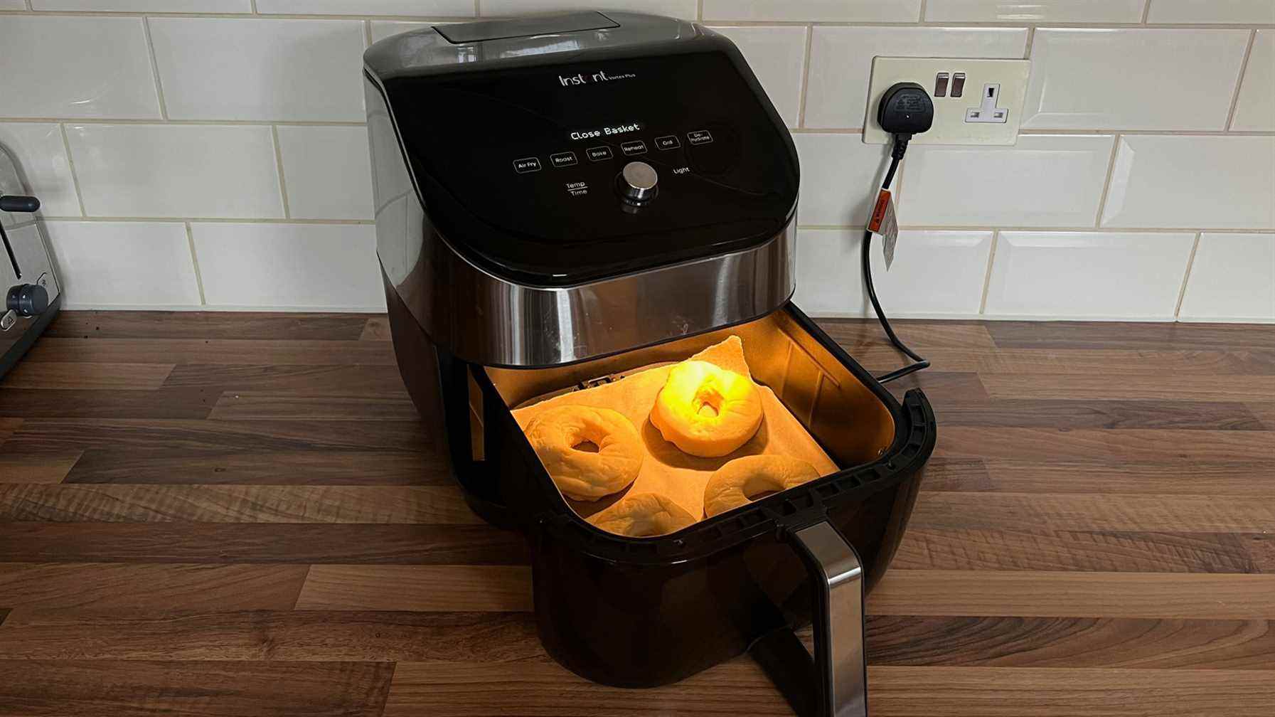 Quatre beignets à l'épreuve de la graisse dans le panier d'une friteuse à air en attente de cuisson