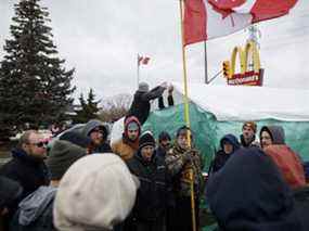 Les gens assistent à une manifestation pour bloquer le pont Ambassador, bloquant le flux de trafic commercial sur le pont vers le Canada depuis Detroit, le 11 février 2022 à Windsor.