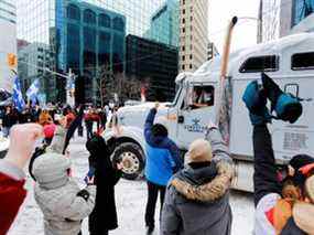 Les gens montrent leur soutien à un camionneur qui part le 19 février 2022 alors que la police d'Ottawa s'efforce de rétablir la normalité dans la capitale après que des camions et des manifestants ont occupé le centre-ville pendant plus de trois semaines pour protester contre les restrictions liées à la pandémie.