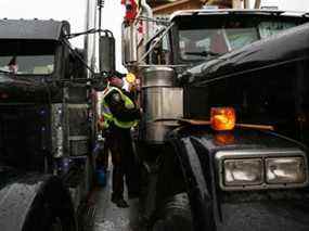 Un policier monte sur le siège passager d'un camion klaxonnant à Ottawa jeudi.