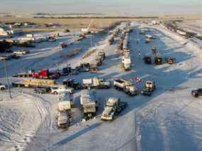 Un convoi de camions de manifestants du mandat du vaccin anti-COVID-19 continue de bloquer l'autoroute au passage frontalier américain très fréquenté à Coutts, en Alberta, le mercredi 2 février 2022.