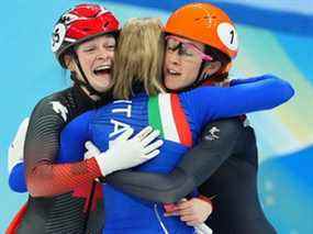 La médaillée d'or Arianna Fontana d'Italie, la médaillée d'argent Suzanne Schulting des Pays-Bas et la médaillée de bronze Kim Boutin du Canada célèbrent à la fin de la course.