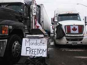 Des manifestants contre les mandats de vaccination avec des camions et d'autres véhicules ornés de pancartes et de drapeaux canadiens se rassemblent sur ON-3 près du pont Ambassador mercredi à Windsor, en Ontario.