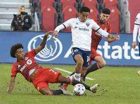 Le milieu de terrain du Toronto FC Jahkeele Marshall-Rutty défie un joueur de DC United.