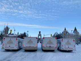 Les véhicules de « transport des délinquants » de la Police provinciale de l'Ontario arrivent tôt vendredi sur la rue Elgin devant le monument aux morts en prévision d'une opération policière visant les manifestants du Freedom Convoy.