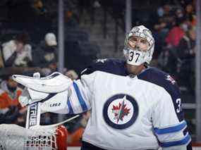 Connor Hellebuyck des Jets de Winnipeg regarde pendant la deuxième période contre les Flyers de Philadelphie au Wells Fargo Center le 1er février 2022 à Philadelphie.