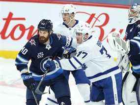 Adam Brooks, ici aux prises avec le défenseur des Jets Jordie Benn lors d'un match la saison dernière, est maintenant membre des équipes de sa ville natale de Winnipeg après avoir été réclamé au ballotage pour une quatrième fois déjà cette saison.