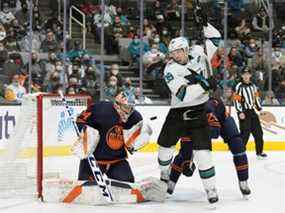 Le gardien de but des Oilers d'Edmonton Stuart Skinner (74) effectue un arrêt alors que le centre des Sharks de San Jose Logan Couture (39) est à l'écran au cours de la deuxième période au SAP Center de San Jose le 14 février 2022.