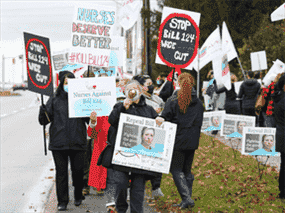 Une manifestation de l'Association des infirmières et infirmiers de l'Ontario contre le projet de loi 124 devant le bureau de la ministre de la Santé Christine Elliot à Ottawa, le 12 novembre 2021. Le sort du projet de loi 124, qui limite les augmentations salariales annuelles, est l'une des questions à discuter lors de la réunion avec l'association et le premier ministre Doug Ford jeudi.