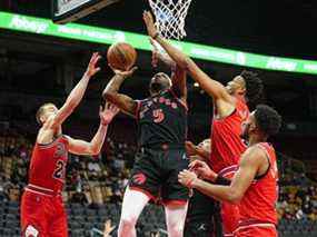 L'attaquant des Raptors de Toronto Precious Achiuwa monte pour faire un panier alors que le garde des Chicago Bulls Matt Thomas et le centre Tony Bradley défendent au cours du premier quart à la Scotiabank Arena.