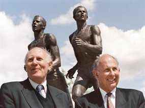 L'Anglais Sir Roger Bannister (à gauche) et l'Australien John Landy posent à Vancouver sur une photo d'archive de 1994.  La statue derrière eux commémore leur course d'un mile aux Jeux de l'Empire britannique à Vancouver en 1954.