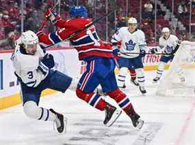 Nick Suzuki (à droite) des Canadiens assène un coup sûr à Justin Holl des Maple Leafs lors de la deuxième période au Centre Bell le lundi 21 février 2022 à Montréal.