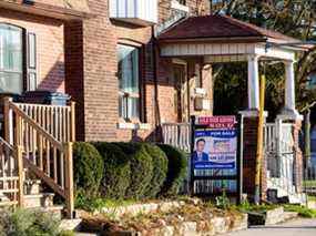 Une enseigne à vendre affichée à l'extérieur d'une maison à Toronto.