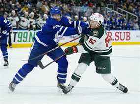 Connor Dewar (à droite) du Minnesota Wild tire la rondelle alors qu'il est touché par Ilya Lyubushkin des Maple Leafs au cours de la deuxième période au Scotiabank Arena le jeudi 24 février 2022.