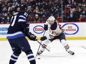 Le centre des Oilers d'Edmonton Connor McDavid (97) patine vers l'ailier gauche des Jets de Winnipeg Kyle Connor (81) en première période au Centre Canada Vie le 19 février 2022.